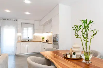 a kitchen and dining room with a wooden table at Eleni's Cozy Apartments Near Athens Airport By SEM in Koropíon