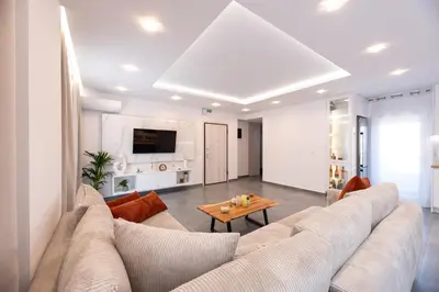 a living room with a large couch and a table at Eleni's Cozy Apartments Near Athens Airport By SEM in Koropíon