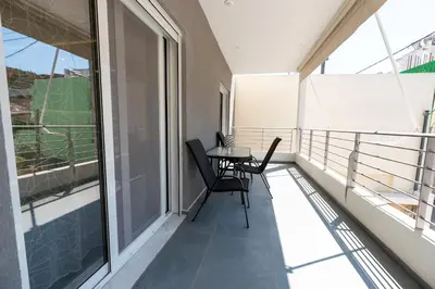 a balcony with a table and chairs on it at Eleni's Cozy Apartments Near Athens Airport By SEM in Koropíon