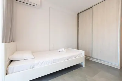 a white bedroom with a bed and a closet at Eleni's Cozy Apartments Near Athens Airport By SEM in Koropíon