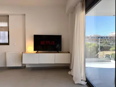 a living room with a television on a white cabinet at M58 Pool Residence - Glyfada Central - Miltiadou 58 by K&M in Athens
