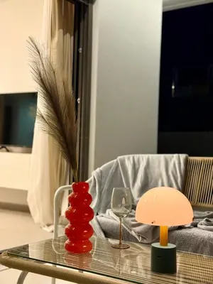 a glass table with a vase and a wine glass at M58 Pool Residence - Glyfada Central - Miltiadou 58 by K&M in Athens