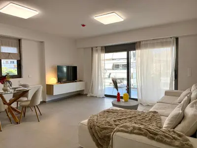a living room with a couch and a table and a television at M58 Pool Residence - Glyfada Central - Miltiadou 58 by K&M in Athens