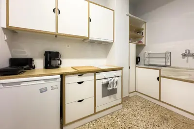 a small kitchen with white cabinets and a sink at Casa Bianca in Pagrati in Athens