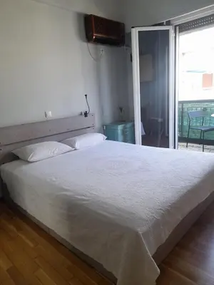 a bedroom with a large white bed and a television at Sharing can change the world! in Athens