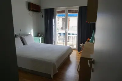 a bedroom with a white bed and a window at Sharing can change the world! in Athens