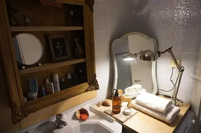 a bathroom with a sink and a mirror and a lamp at Sharing can change the world! in Athens