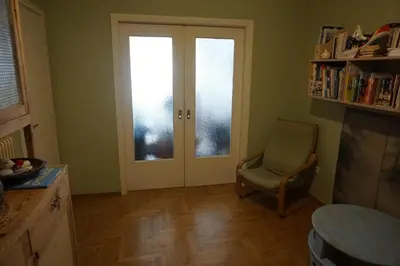 a living room with a door and a chair and a window at Sharing can change the world! in Athens