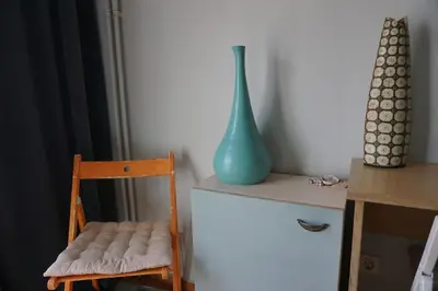 a blue vase sitting on a table next to a chair at Sharing can change the world! in Athens