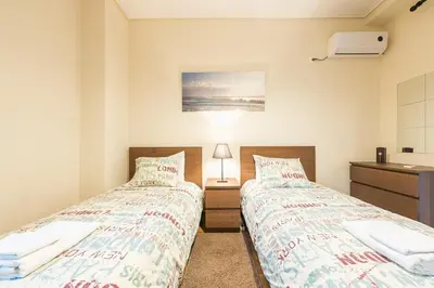 two beds in a bedroom with a sink and a desk at Heart of Athens Stay Apartment in Athens