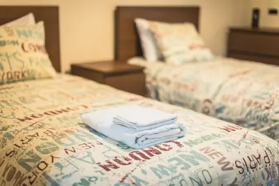 two beds with towels sitting on top of them at Heart of Athens Stay Apartment in Athens