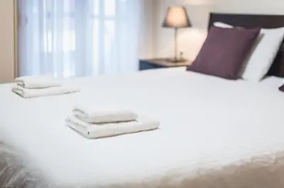 a white bed with towels on top of it at Heart of Athens Stay Apartment in Athens
