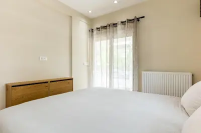 a bedroom with a white bed and a window at The Sea Breeze, Glyfada in Athens
