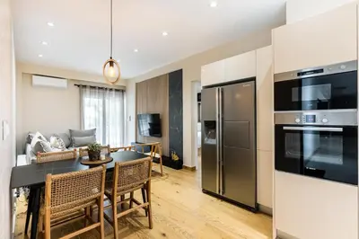 a kitchen and living room with a table and appliances at The Sea Breeze, Glyfada in Athens