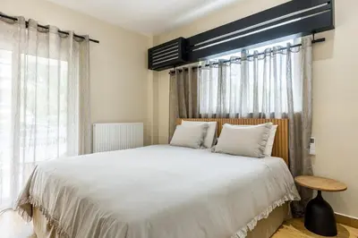 a bedroom with a large bed and a window at The Sea Breeze, Glyfada in Athens