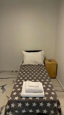 a bed with a black and white blanket and a pillow at LuxBlue Apartment Kypseli in Athens