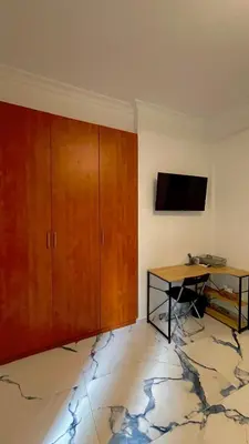 a room with a desk and a tv on a wall at LuxBlue Apartment Kypseli in Athens