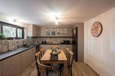 a kitchen with a wooden table and chairs in it at 3BR Private House with 3 Bathrooms & Amazing Balcony in Athens