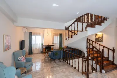 a staircase in a living room with a couch and chairs at 3BR Private House with 3 Bathrooms & Amazing Balcony in Athens