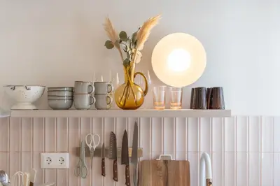 a shelf with a vase with flowers and utensils at 1BR Designer Apt Next To Metro & 15 minutes to Acropolis in Athens