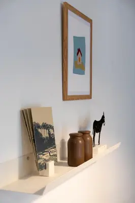 a shelf with a book and a cat figurine on it at 1BR Designer Apt Next To Metro & 15 minutes to Acropolis in Athens