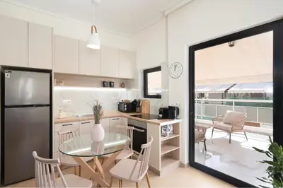 a kitchen and dining room with a table and chairs at 1BR Cozy Apt Near Metro with Huge Balcony &City View in Athens