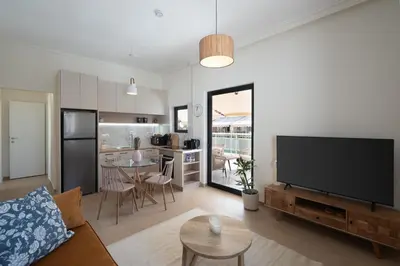 a living room with a flat screen tv and a kitchen at 1BR Cozy Apt Near Metro with Huge Balcony &City View in Athens