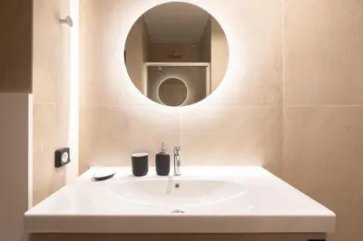 a bathroom with a white sink and a mirror at 2BR Apartment, Access to Rooftop Retreat with Sauna & Jacuzzi in Athens