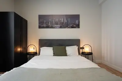 a bedroom with a large white bed with two lamps at 2BR Apartment, Access to Rooftop Retreat with Sauna & Jacuzzi in Athens