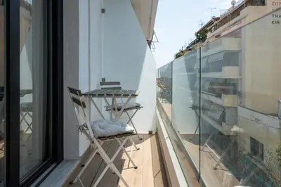 a balcony with a chair next to a window at 2BR Apartment, Access to Rooftop Retreat with Sauna & Jacuzzi in Athens