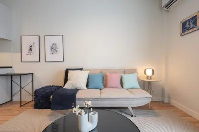 a living room with a couch and a table at Stylish 2BR Apt, Rooftop with Sauna & Hot Tub in Athens