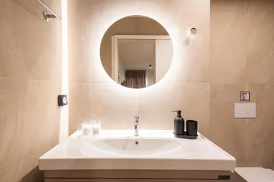a bathroom with a white sink and a mirror at Stylish 2BR Apt, Rooftop with Sauna & Hot Tub in Athens