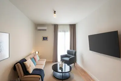 a living room with a couch and a tv on a wall at Stylish 2BR Apt, Rooftop with Sauna & Hot Tub in Athens