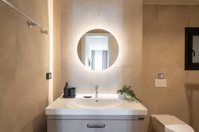 a bathroom with a white sink and a mirror at 2BR Apt Access To Rooftop with Sauna & Jacuzzi in Athens