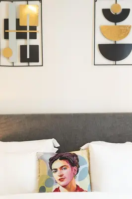 a bedroom with a bed with two pillows and posters at 2BR Apt Access To Rooftop with Sauna & Jacuzzi in Athens