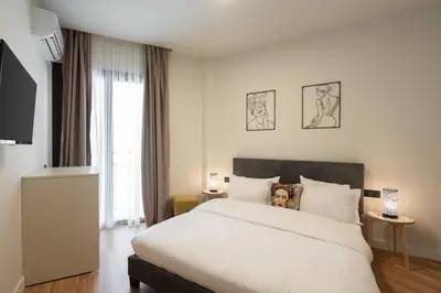 a bedroom with a large white bed and a window at 2BR Apt Access To Rooftop with Sauna & Jacuzzi in Athens