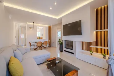 a living room with a couch and a tv at Azure7 Seaside - Luxury Apartment in Varkiza in Varkiza