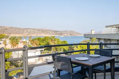 a table and chairs on a balcony with a view of the beach at Azure7 Seaside - Luxury Apartment in Varkiza in Varkiza