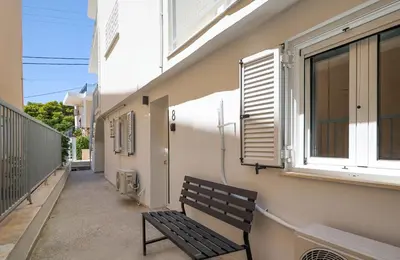 a bench sitting on a balcony next to a window at Muse Studios & Apartments in Agia Marina Aegina