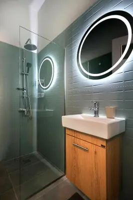 a bathroom with a sink and a shower with a mirror at Muse Studios & Apartments in Agia Marina Aegina