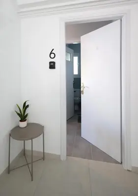 a door leading into a room with a table at Muse Studios & Apartments in Agia Marina Aegina