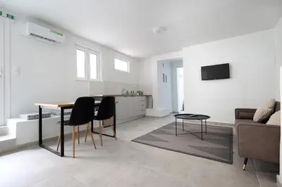 a living room with a table and chairs and a couch at Muse Studios & Apartments in Agia Marina Aegina