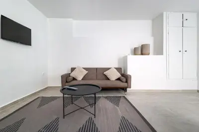 a living room with a couch and a table at Muse Studios & Apartments in Agia Marina Aegina