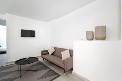 a living room with a couch and a table at Muse Studios & Apartments in Agia Marina Aegina