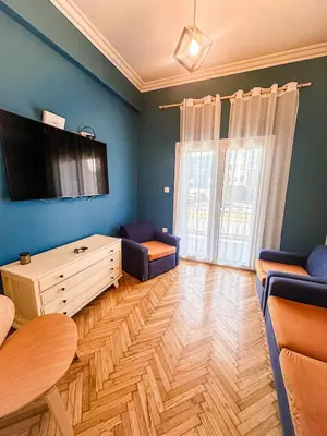 a living room with a table and a tv on the wall at The North Nest in Athens