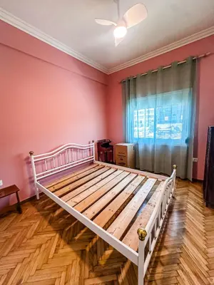 a bedroom with a white bed in a room with pink walls at The North Nest in Athens