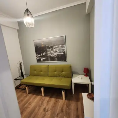 a living room with a green couch in a room at Athens Nest one in Athens