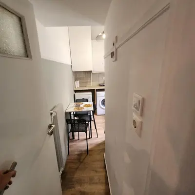 a hallway of a kitchen with a table and a door at Athens Nest one in Athens