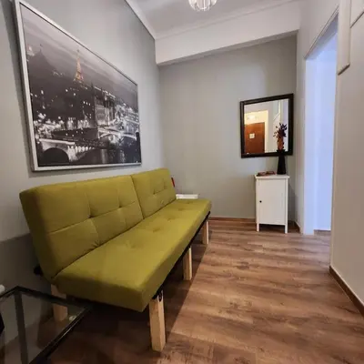 a living room with a green couch in a room at Athens Nest one in Athens