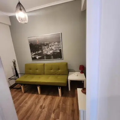 a living room with a green couch in a room at Athens Nest one in Athens